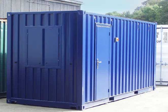 A blue exterior of a 20ft converted shipping container office conversions with a personnel door and shuttered window, positioned on an industrial site.